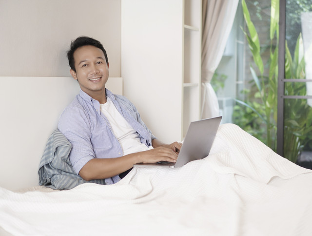 Ilustrasi pria memangku laptop.  Foto: Shutterstock