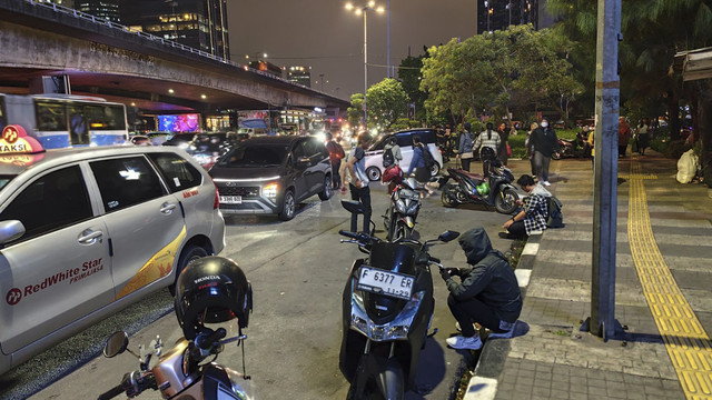 Pengendara ojol menepi untuk beristirahat di persimpangan Slipi usai menerjang kemacetan. Foto: Rachmadi Rasyad/kumparan