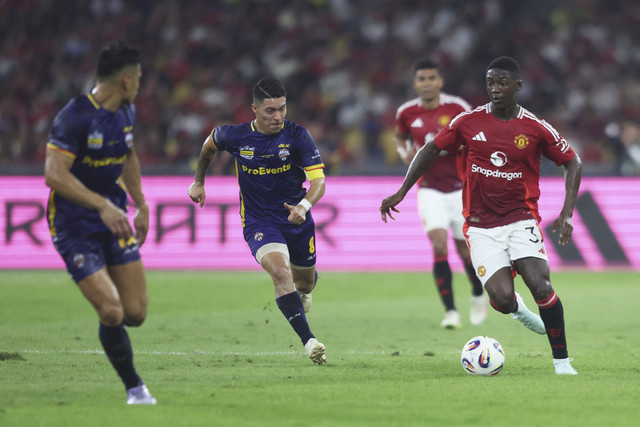 Pemain Manchester United Kobbie Mainoo berusaha melewati dua pemain ASEAN All Star pada pertandingan persahabatan di Stadion Bukit Jalil, Malaysia, Rabu (28/5/2025). Foto: Hasnoor Hussain/Reuters