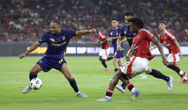 Pemain Mancehster United Patrick Dorgu berebut bola dengan dua pemain ASEAN All pada laga persahabatan di Stadion Bukit Jalil, Malaysia, Rabu (28/5/2025). Foto: Hasnoor Hussain/Reuters