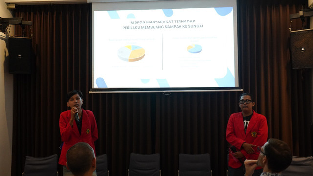 Sebelah kanan Aristoteles bersama temannya menjelaskan hasil penelitiannya tentang dampak pencemaran Kali Surabaya di Wisma Jerman, Jl. Taman AIS Nasution, Embong Kaliasin, Surabaya, Jatim