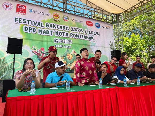 Peserta juara 1 lomba makan bakcang dengan membuka mulut membuktikan bahwa makanan sudah habis. Foto: Rabiansyah/Hi!Pontianak.
