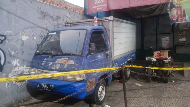 Polisi memasang garis batas lokasi pembunuhan di toko grosir sembako milik korban dugaan pembunuhan 'Koh' Alex yang terletak di pertigaan Bojong, Pondok Gede, Kota Bekasi, Sabtu (31/5). Foto: Thomas Bosco/kumparan