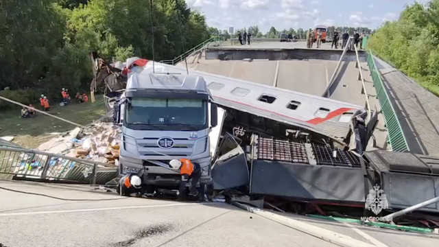 Petugas layanan darurat bekerja di lokasi kejadian, setelah sebuah jembatan jalan ambruk ke rel kereta api di wilayah Bryansk, Rusia, Minggu (1/6/2025). Foto: Stringer/REUTERS