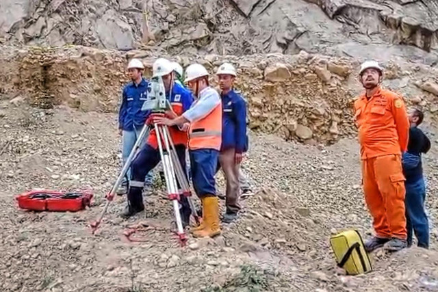 Petugas saat menggunakan alat Total Station untuk mendeteksi pergerakan tanah di longsoran galian C Gunung Kuda Cirebon, Senin (2/6/2025) Foto: kumparan