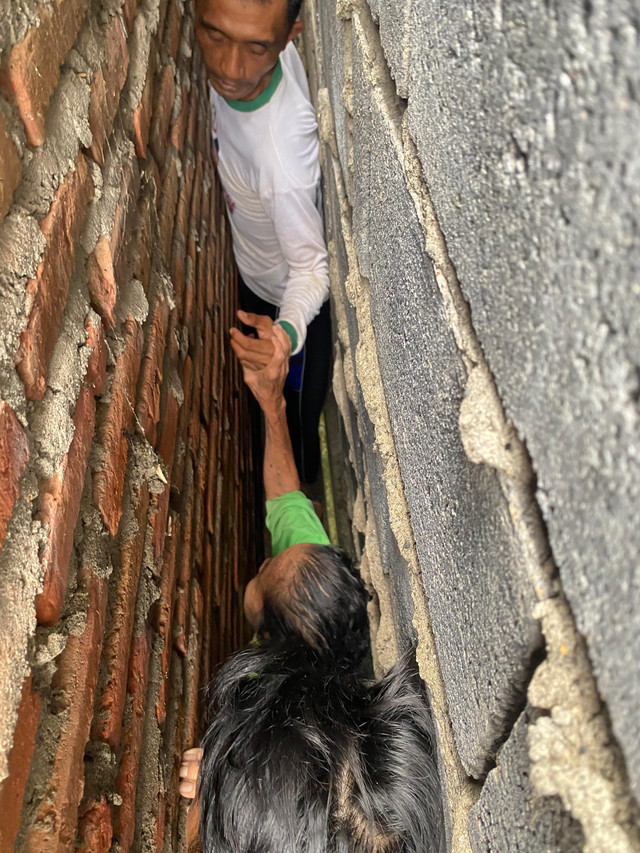 Petugas Damkar evakuasi seorang nenek bernama Rami yang terjepit di sela-sela tembok rumah warga di Dusun Prambon gang 01, Desa Klotok, Kecamatan Balongpanggang, Kabupaten Gresik. Foto: Damkar Kabupaten Gresik
