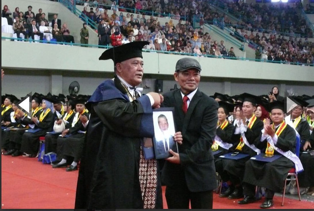 Rektor UNY, Sumaryanto, menyerahkan ijazah Iqbal kepada sang kakak. Foto: Dok. UNY