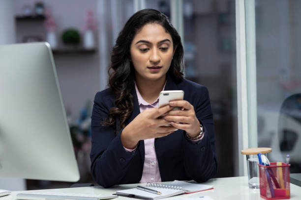 seseorang di meja kerja yang terlihat fokus menatap ponsel dengan ekspresi kurang produktif https://www.istockphoto.com/id/foto/wanita-bisnis-muda-foto-stok-gm1309076999-398900899?searchscope=image%2Cfilm.