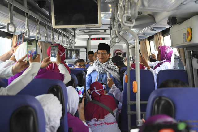 Menteri Agama Nasaruddin Umar (tengah) menyapa jamaah calon haji Indonesia saat perjalanan untuk menunaikan wukuf di Arafah, Makkah, Arab Saudi, Rabu (4/6/2025). Foto: Andika Wahyu/ANTARA FOTO