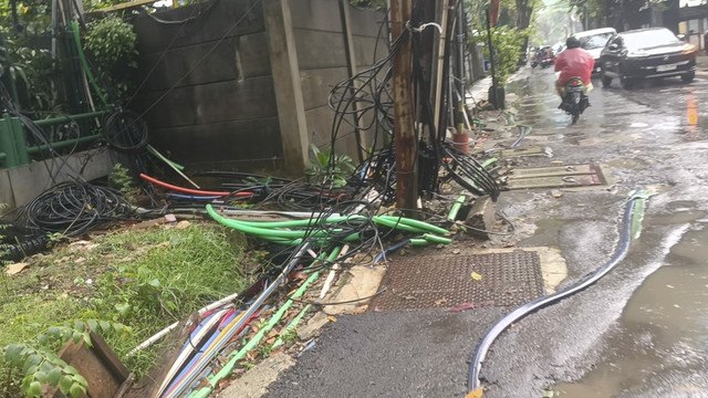 Potret kesemerawutan kabel-kabel tanam yang menyembul dari tanah dan saluran air di Jalan Kuningan Barat Raya, Jakarta Selatan, Rabu (4/6/2025). Foto: Thomas Bosco/kumparan