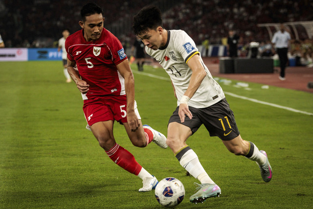 Pemain Indonesia Rizky Ridho membayangi pemain China Wang Yudong pada pertandingan kualifikasi Piala Dunia 2026 antara Indonesia vs China di Stadion Gelora Bung Karno di Jakarta, Kamis (5/6/2025). Foto: Yasuyoshi Chiba/AFP