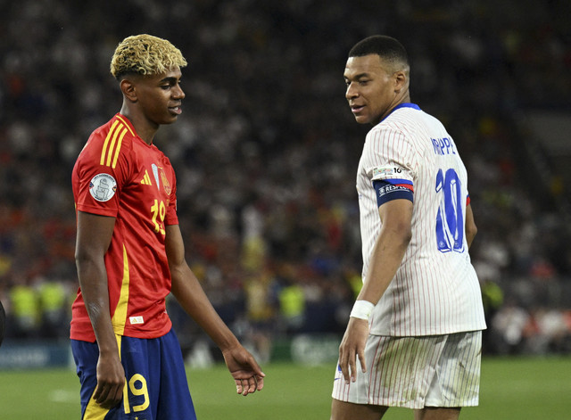 Pemain Timnas Spanyol Lamine Yamal berpapasan dengan pemain Timnas Prancis Kylian Mbappe pada pertandingan semifinal UEFA Nations League di MHPArena, Stuttgart, Jerman, Kamis (5/6/2025). Foto: Annegret Hilse/Reuters