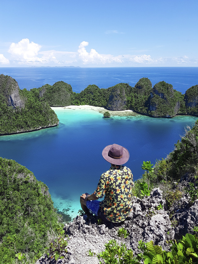 Turis menikmati keindahan Raja Ampat. Foto: Shutterstock