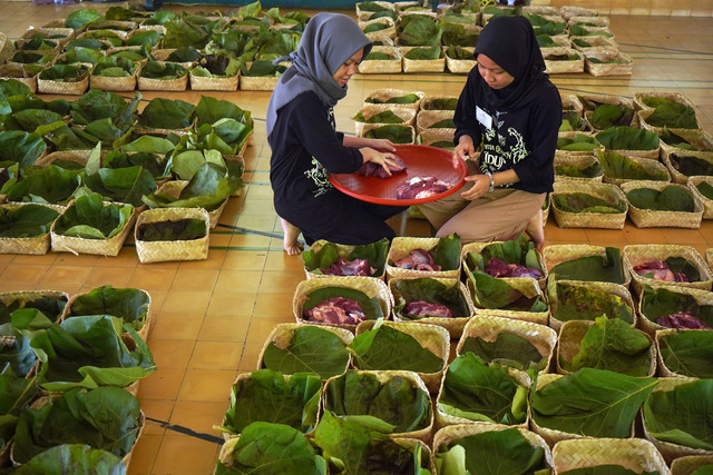 Warga membungkus daging kurban dengan daun jati di Masjid Margoyuwono, Kraton, Yogyakarta, Jumat (6/6/2025). Foto: ANTARA FOTO/Hendra Nurdiyansyah