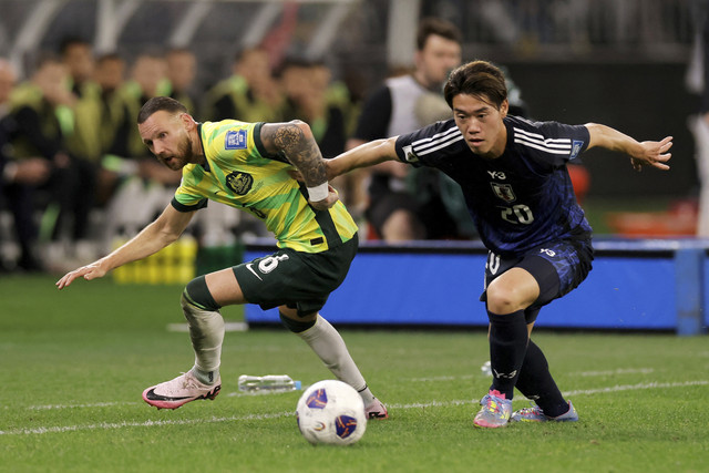 Pemain Timnas Australia Martin Boyle berebut bola dengan pemain Timnas Jepang Kota Tawaratsumida pada pertandingan Kualifikasi Piala Dunia 2026 di Stadion Perth, Perth, Australia, Kamis (5/6/2025). Foto: Richard Wainwright/Reuters