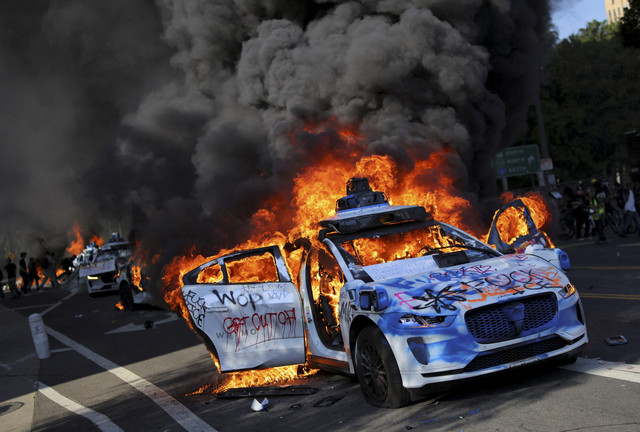 Mobil-mobil Waymo terbakar selama protes terhadap razia imigrasi federal di pusat kota Los Angeles, California, AS, Minggu (8/6/2025). Foto: Daniel Cole/REUTERS 