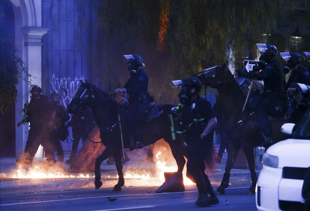 Petugas polisi bekerja dengan menunggang kuda saat melakukan aksi protes menentang razia imigrasi federal di pusat kota Los Angeles, California, Minggu (8/6/2025). Foto: Aude Guerrucci/REUTERS