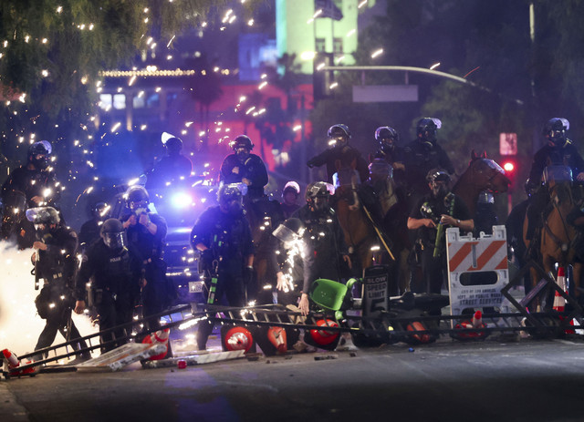 Petugas kepolisian berjaga-jaga saat aksi protes menentang razia imigrasi federal di pusat kota Los Angeles, California, AS, Minggu (8/6/2025). Foto: Aude Guerrucci/REUTERS