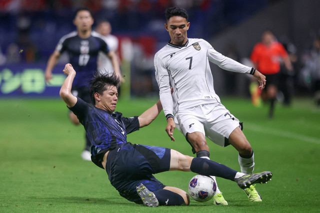 Pemain Timnas Jepang Kota Takai berebut bola dengan pemain Timnas Indonesia Marselino Ferdinan pada pertandingan Grup C Ronde 3 Kualifikasi Piala Dunia 2026 di Stadion Kota Suita, Suita, Jepang, Senin (10/6/2025). Foto: AFP / STR