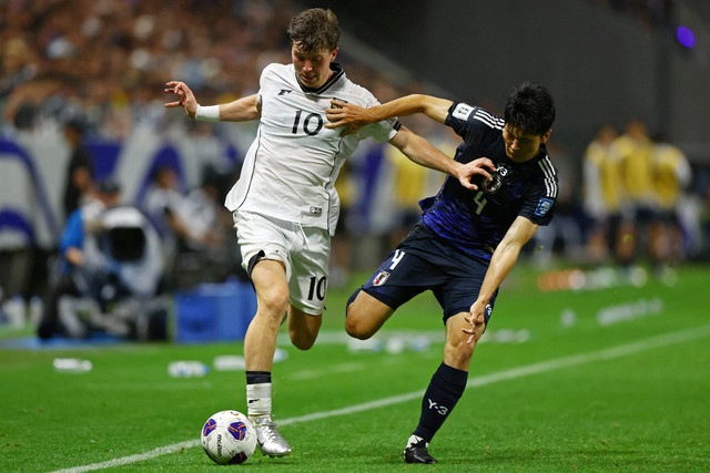 Pemain Timnas Jepang Junnosuke Suzuki berebut bola dengan pemain Timnas Indonesia Ole Lennard Romenij pada pertandingan Grup C Ronde 3 Kualifikasi Piala Dunia 2026 di Stadion Kota Suita, Suita, Jepang, Senin (10/6/2025). Foto: Issei Kato/REUTERS