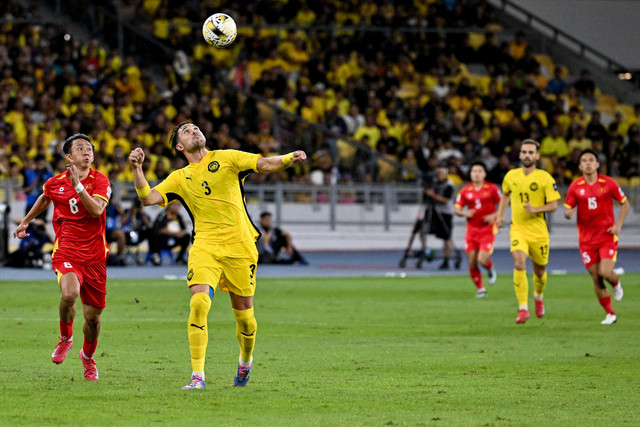 Pemain Timnas Malaysia Facundo Tomas Garces berebut bola dengan pemain Timnas Vietnam Chau Ngoc Quang pada pertandingan Grup F Kualifikasi Piala Asia 2027 di Stadion Bukit Jalil, Kuala Lumpur, Malaysia, Selasa (10/6/2025). Foto: Mohd Rasfan/AFP