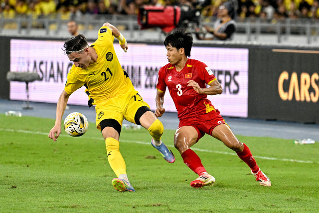 Pemain Timnas Malaysia Dion Cools berebut bola dengan pemain Timnas Vietnam Nguyen Van Vi pada pertandingan Grup F Kualifikasi Piala Asia 2027 di Stadion Bukit Jalil, Kuala Lumpur, Malaysia, Selasa (10/6/2025). Foto: Mohd Rasfan/AFP