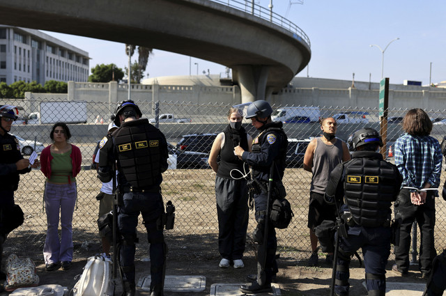 Petugas penegak hukum menahan para demonstran di dekat Gedung Federal Edward R. Roybal saat melakukan aksi protes menentang razia imigrasi federal di pusat kota Los Angeles, California, AS, Selasa (10/62025). Foto: David Swanson/REUTERS