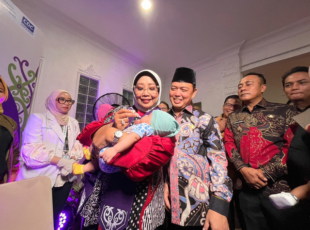 Gubernur Kalbar, Ria Norsan dan Ketua TP PKK Kalbar Erlina sedang memberikan imuniasasi kepada salah satu anak. Foto : Rabiansyah/Hi!Pontianak.