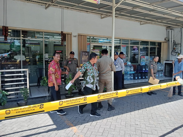 Satpol PP dan Dishub Kota Surabaya menyegel tempat usaha yang juru parkirnya tidak mengenakan rompi parkir gratis, Kamis (12/6/2025). Foto: Dok mili.id