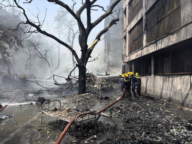 Petugas pemadam kebakaran bekerja di lokasi pesawat yang jatuh di kota Ahmedabad, negara bagian Gujarat, India barat laut, Kamis (12/6/2025). Foto: Ajit Solanki/AP Photo