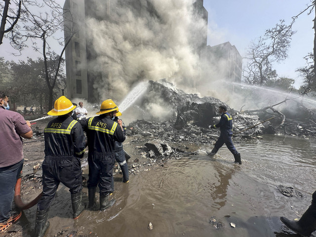 Anggota tim penyelamat bekerja saat asap mengepul di lokasi jatuhnya pesawat Air India di Ahmedabad, India, Kamis (12/6/2025). Foto: Amit Dave/REUTERS