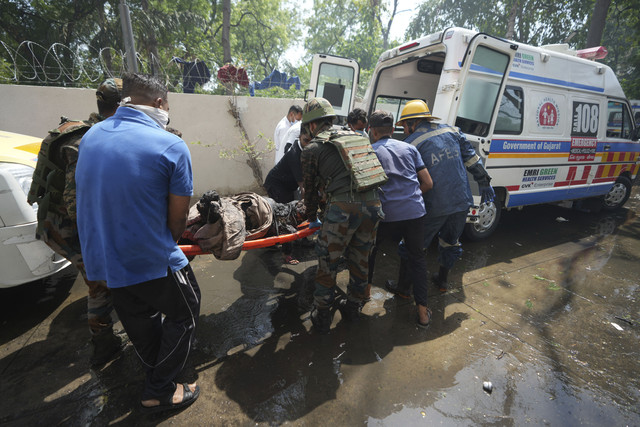 Para petugas penyelamat di lokasi pesawat yang jatuh di kota Ahmedabad, negara bagian Gujarat, India barat laut, Kamis (12/6/2025). Foto: Ajit Solanki/AP Photo