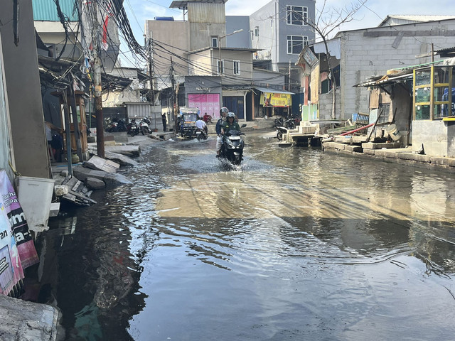 Genangan air setinggi mata kaki imbas banjir rob di Jalan Dermaga Ujung 2 Blok Empang, Muara Angke, Jakarta Utara, Jumat (13/6/2025). Foto: Nasywa Athifah/kumparan