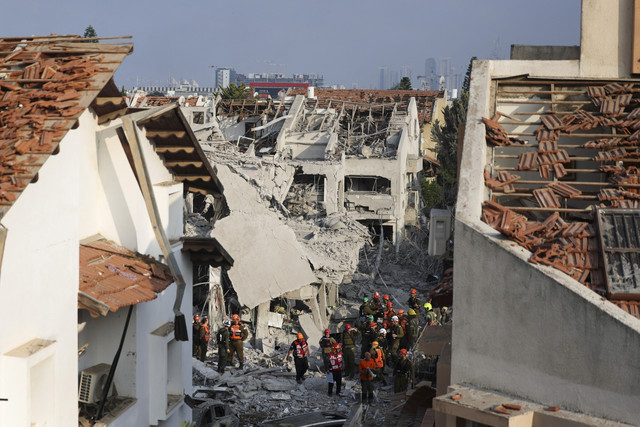 Petugas tanggap darurat melakukan pemeriksaan usai serangan Iran di salah satu perumahan di Tel Aviv, Israel, Sabtu (14/6/2025). Foto: Ronen Zvulun/Reuters