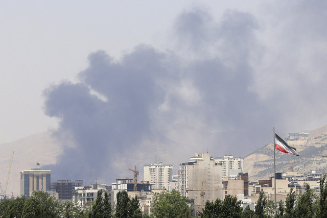 Asap mengepul pada hari kedua dari depot minyak Shahran, barat laut Teheran, Iran, Senin (16/6/2025). Foto: Atta Kenare/AFP