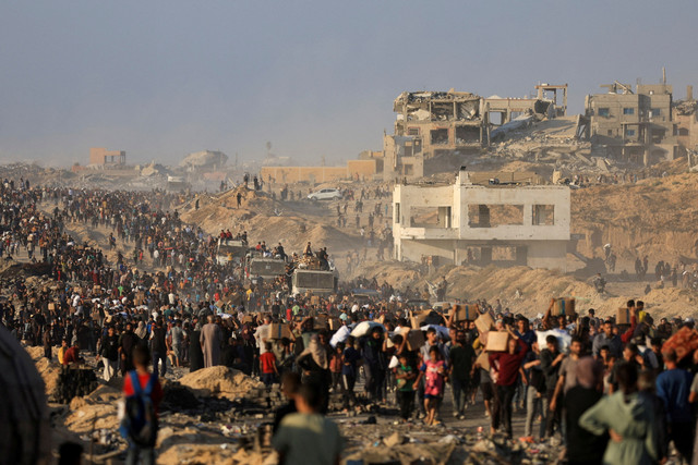 Warga Palestina yang mengungsi mengangkut paket bantuan kemanusiaan di Beit Lahia, Jalur Gaza utara, Senin (16/6/2025). Foto: Dawoud Abu Alkas/REUTERS