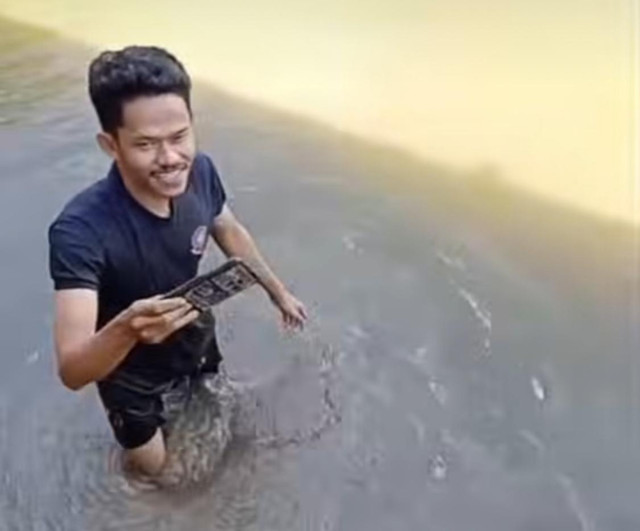 Petugas Damkar Sanggau saat berhasil menemukan HP bocil yang terjatih dalam kolam. Foto: Dok. instagram @sanggauinformasi