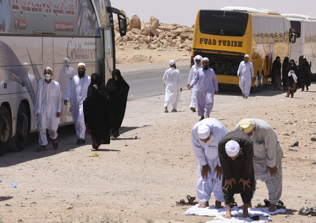 Sejumlah jemaah haji Iran melaksanakan Salat di perbatasan Arar antara Irak dan Arab Saudi, Selasa (17/6/2025). Foto: Ahmed Saad/Reuters