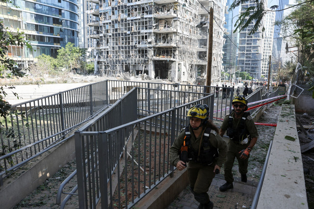 Petugas darurat bekerja di lokasi terdampak setelah serangan Iran di Ramat Gan, Israel 19 Juni 2025. Foto: REUTERS/Nir Elias
