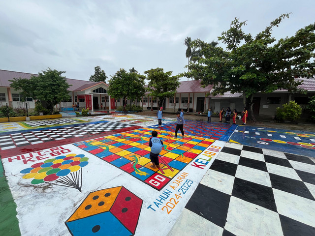 Beberapa murid SDN 64 sedang mempermainkan ular tangga yang digambar di halaman sekolah. Foto: Rabiansyah/Hi!Pontianak