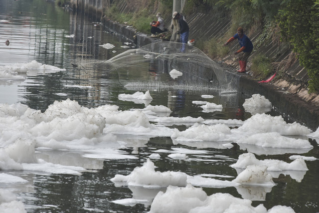 Warga menjala ikan di Pintu Air 3 Kanal Banjir Timur (KBT) yang tercampur limbah busa di Marunda, Jakarta Utara, Kamis (19/6/2025). Foto: FAH/ANTARA FOTO