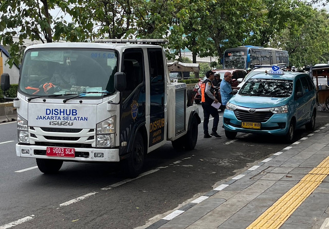 Petugas Dinas Perhubungan Jakarta Selatan menertibkan aksi parkir liar di depan Stasiun Cawang, Kamis (19/6/2025). Foto: Syahrul Ghiffari/kumparan