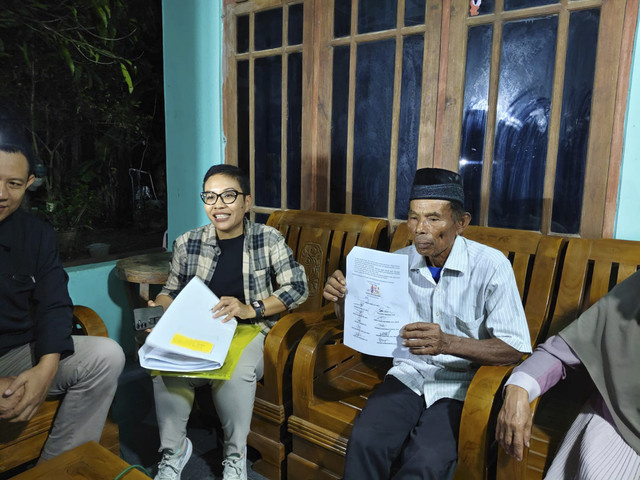 Mbah Tupon (berpeci) bersama kuasa hukumnya Sukiratnasari (kemeja motif kotak-kotak) di kediaman Mbah Tupon di Kasihan, Kabupaten Bantul, Kamis (19/6/2025). Foto: Arfiansyah Panji Purnandaru/kumparan