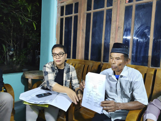 Mbah Tupon (berpeci) bersama kuasa hukumnya Sukiratnasari (kemeja motif kotak-kotak) di kediaman Mbah Tupon di Kasihan, Kabupaten Bantul, Kamis (19/6/2025). Foto: Arfiansyah Panji Purnandaru/kumparan