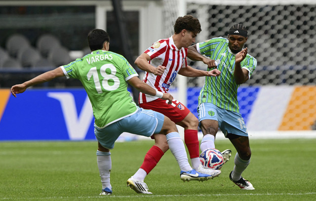 Pemain Atletico Madrid Julian Alvarez berebut bola dengan dua pemain Seattle Sounders Obed Vargas dan Jon Bell). Foto: Pablo Porciuncula/AFP