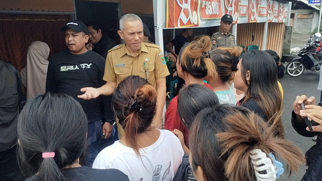 Warga yang menempati lahan milik Pemkab Bolmong di Bitung Karangria Manado berdiskusi dengan perwakilan Pemkab Bolmong saat pelaksanaan pengambilalihan lahan pada Selasa 17 Juni 2025.