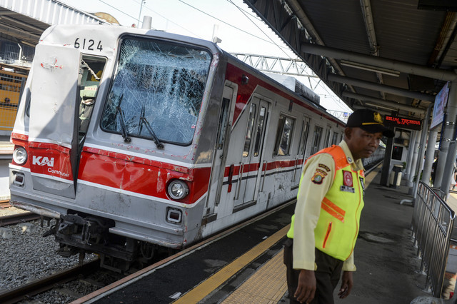 Petugas berjaga di samping kereta rel listrik (KRL) Commuter Line yang rusak akibat ditabrak truk di Stasiun Tangerang, Kota Tangerang, Banten, Jumat (20/6/2025). Foto: Putra M. Akbar/Antara Foto