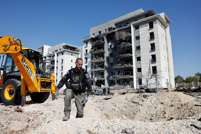 Petugas polisi memeriksa lokasi jatuhnya rudal Iran di Israel, di Be'er Sheva, Israel, 20 Juni 2025. Foto: REUTERS/Amir Cohen