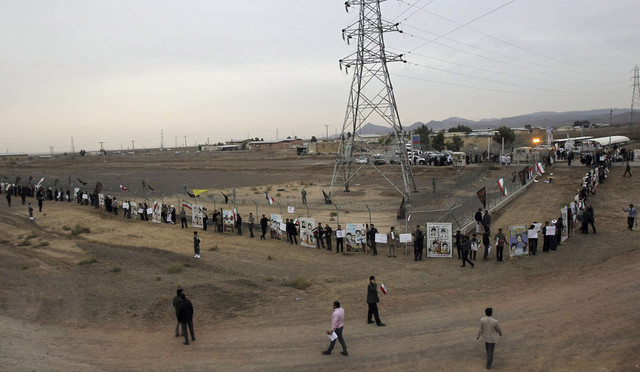 Para mahasiswa Iran membentuk rantai manusia dalam sebuah protes untuk mempertahankan program nuklir negara mereka di luar Fasilitas Konversi Uranium Fordo di Qom, Iran (19/11/2013). Foto: CHAVOSH HOMAVANDI/AFP