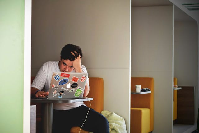 Ilustrasi Orang yang Sedang Stress. https://www.pexels.com/photo/man-in-white-shirt-using-macbook-pro-52608/
